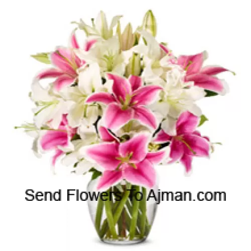 White And Pink Lilies With Some Ferns In A Glass Vase