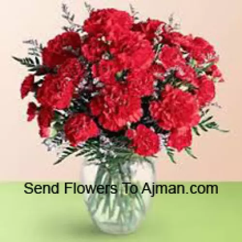 36 Red Carnations With Seasonal Fillers In A Glass Vase